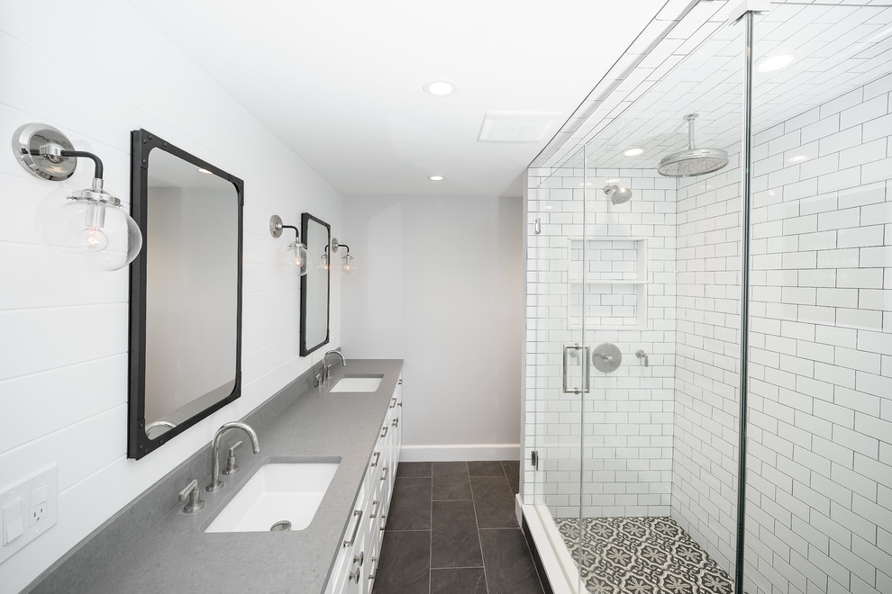 На фото: главная ванная комната среднего размера в стиле неоклассика (современная классика) с фасадами в стиле шейкер, белыми фасадами, двойным душем, биде, белой плиткой, керамической плиткой, серыми стенами, полом из цементной плитки, накладной раковиной, столешницей из искусственного кварца, черным полом и душем с распашными дверями с
