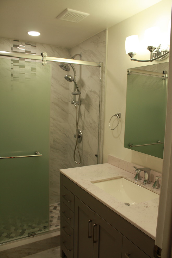 Exemple d'une petite salle de bain tendance avec un placard à porte shaker, des portes de placard grises, un carrelage gris, un mur blanc, un lavabo encastré, une cabine de douche à porte coulissante et un plan de toilette beige.