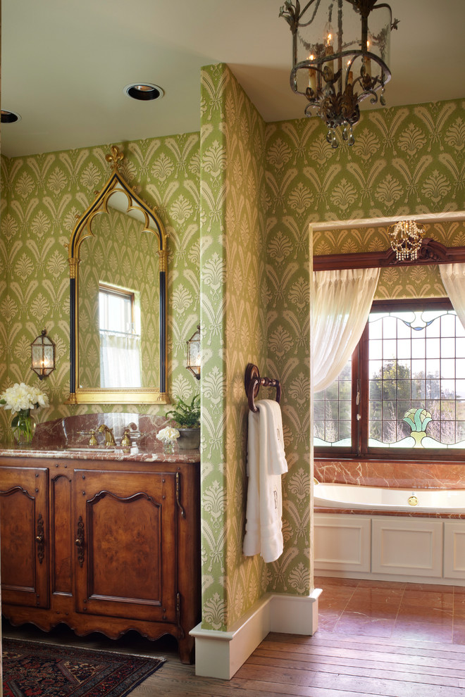 他の地域にあるトラディショナルスタイルのおしゃれな浴室 (アンダーカウンター洗面器、濃色木目調キャビネット、緑の壁、落し込みパネル扉のキャビネット) の写真