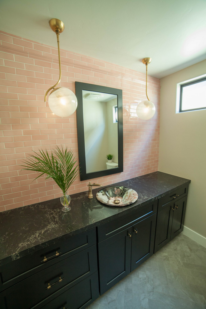 Photo of a medium sized coastal bathroom in San Luis Obispo with shaker cabinets, black cabinets, a one-piece toilet, pink tiles, ceramic tiles, beige walls, porcelain flooring, a vessel sink, engineered stone worktops, grey floors and black worktops.