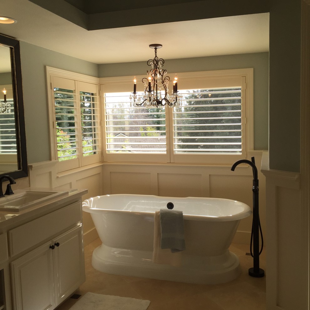 Inredning av ett klassiskt stort en-suite badrum, med luckor med upphöjd panel, vita skåp, ett fristående badkar, blå väggar, ett nedsänkt handfat och beiget golv