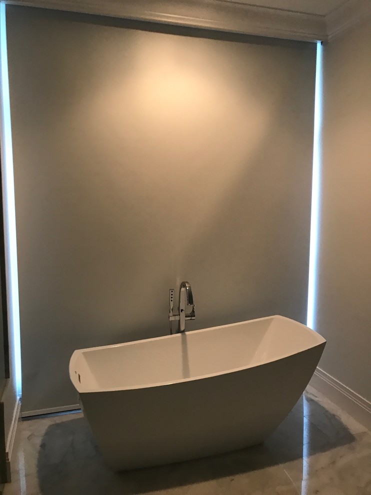 Foto di una stanza da bagno padronale minimal con vasca freestanding, pavimento in marmo e pavimento beige