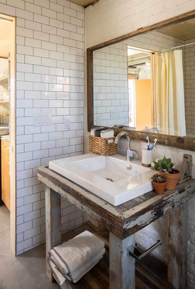 Ejemplo de cuarto de baño industrial con encimera de madera, ducha abierta, baldosas y/o azulejos blancos, baldosas y/o azulejos de cemento, suelo de cemento y aseo y ducha