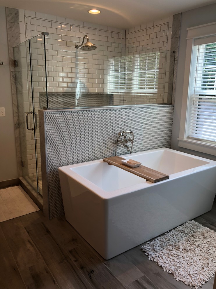 Cette photo montre une salle de bain avec une douche d'angle, un carrelage blanc, des carreaux de céramique, un sol en carrelage de porcelaine et une cabine de douche à porte battante.