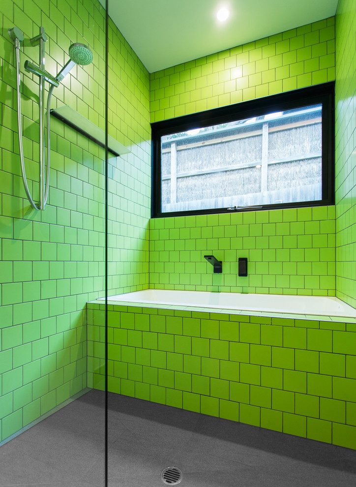 Cette image montre une salle de bain design avec un carrelage vert et une fenêtre.