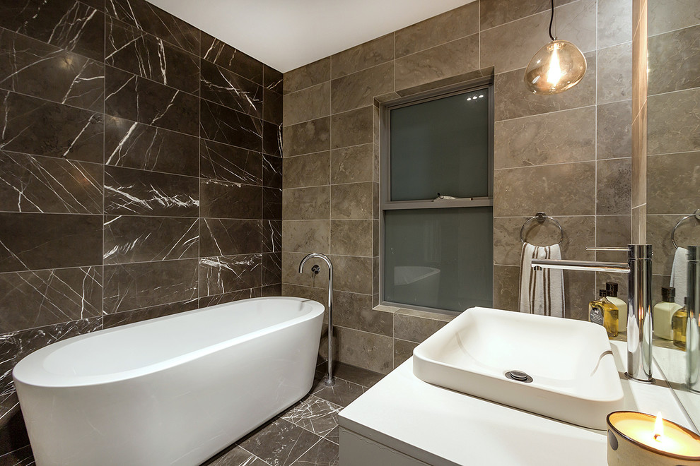 Стильный дизайн: ванная комната в современном стиле с белыми фасадами, отдельно стоящей ванной, коричневой плиткой, коричневыми стенами и настольной раковиной - последний тренд