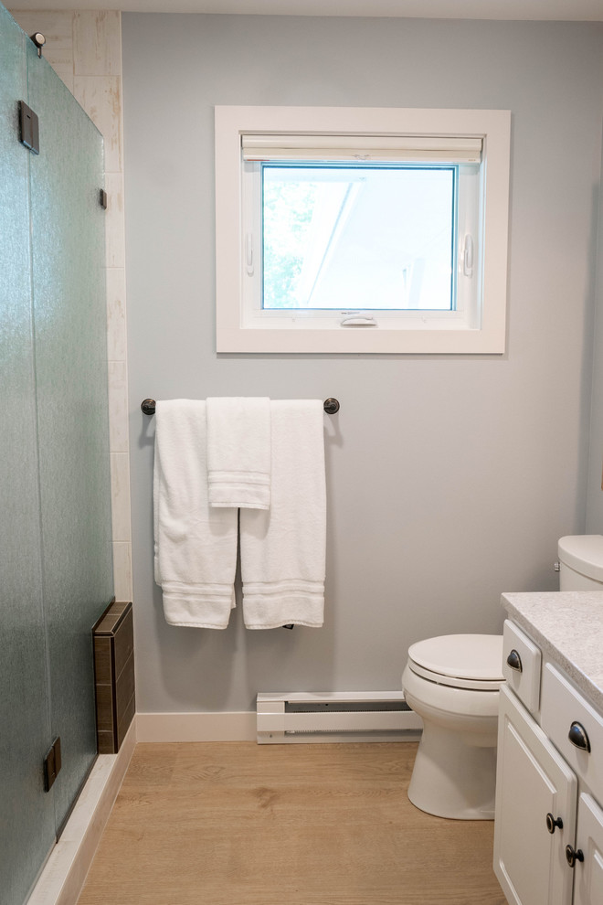 Idéer för ett mellanstort maritimt vit badrum med dusch, med vita väggar, ljust trägolv, beiget golv, luckor med upphöjd panel, vita skåp, en dusch i en alkov, en toalettstol med separat cisternkåpa, ett undermonterad handfat, bänkskiva i kvarts och dusch med gångjärnsdörr