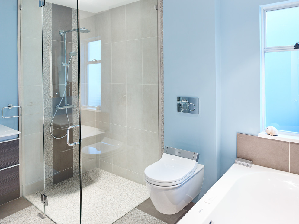 Réalisation d'une salle de bain principale design de taille moyenne avec un placard en trompe-l'oeil, une baignoire d'angle, une douche à l'italienne, WC suspendus, un carrelage de pierre, un mur bleu, un sol en ardoise et un lavabo intégré.