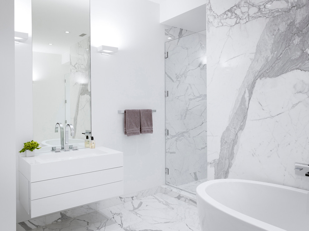 Immagine di una stanza da bagno minimal con ante lisce, ante bianche, vasca freestanding, doccia alcova, piastrelle bianche, lastra di pietra e pareti bianche