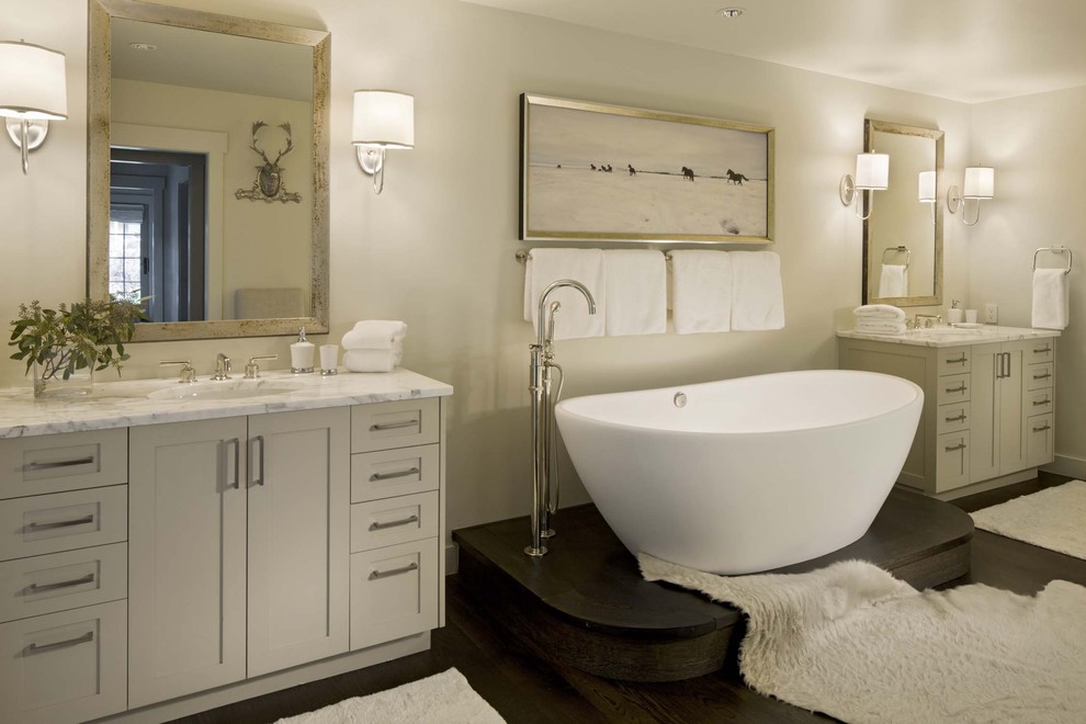 Exempel på ett klassiskt badrum, med ett undermonterad handfat, ett fristående badkar och beige väggar