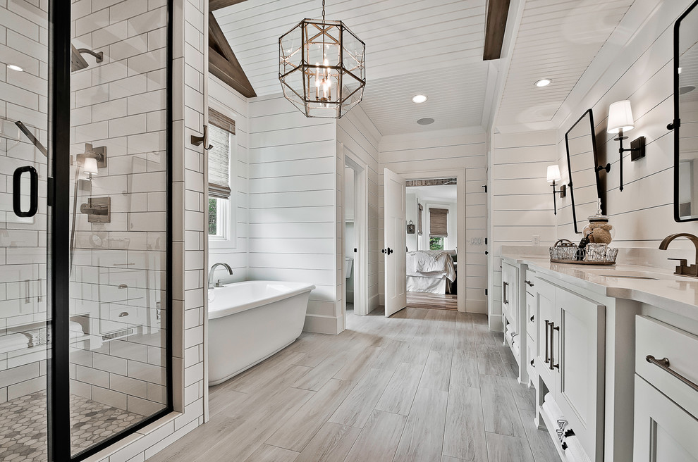Example of a large arts and crafts master white tile and porcelain tile ceramic tile and beige floor bathroom design in Little Rock with raised-panel cabinets, white cabinets, a two-piece toilet, white walls, an undermount sink, quartz countertops, a hinged shower door and white countertops