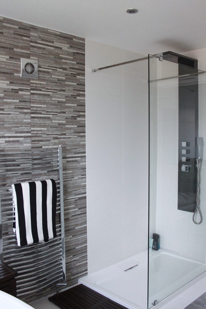 Inspiration for a small modern family bathroom in Buckinghamshire with flat-panel cabinets, white cabinets, a freestanding bath, a walk-in shower, a wall mounted toilet, grey tiles, stone tiles, white walls, porcelain flooring, a vessel sink and wooden worktops.