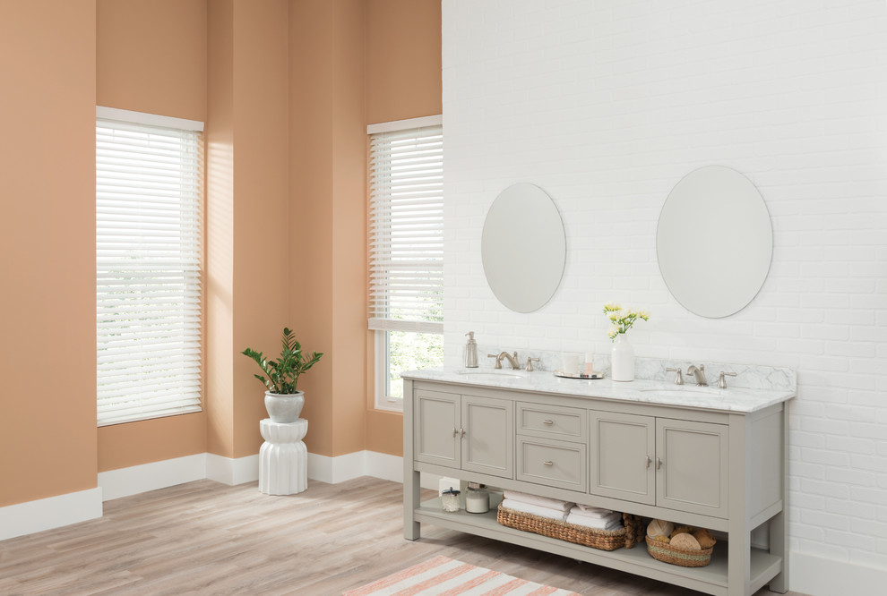 Imagen de cuarto de baño actual con parades naranjas y suelo de madera clara