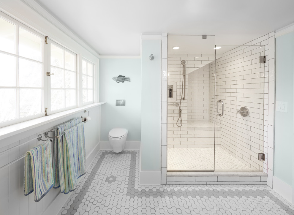 Foto på ett mellanstort vintage en-suite badrum, med en hörndusch, en vägghängd toalettstol, vit kakel, tunnelbanekakel, blå väggar, mosaikgolv, vitt golv och dusch med gångjärnsdörr