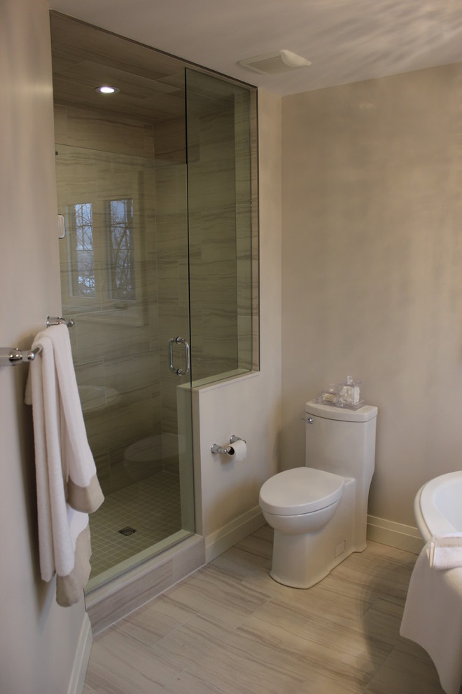 Modelo de cuarto de baño principal contemporáneo grande con bañera exenta, ducha doble, sanitario de una pieza, baldosas y/o azulejos grises, baldosas y/o azulejos de porcelana, paredes grises y suelo de baldosas de porcelana