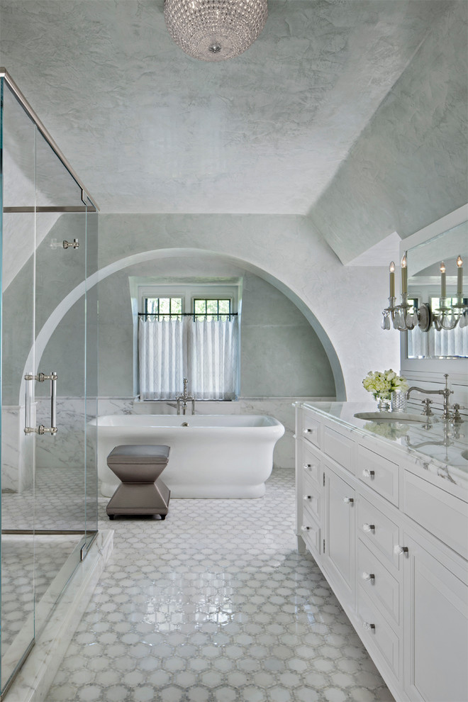 Imagen de cuarto de baño gris y blanco tradicional con puertas de armario blancas y bañera exenta