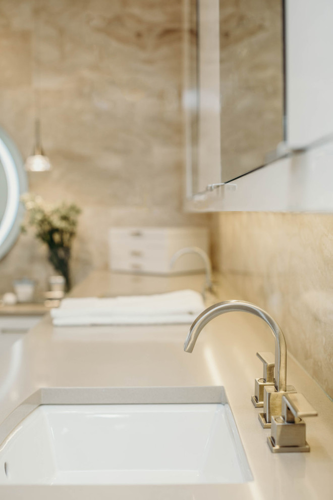 Example of a large trendy master beige tile and marble tile marble floor and beige floor bathroom design in Detroit with flat-panel cabinets, white cabinets, beige walls, an undermount sink, quartz countertops, beige countertops and a one-piece toilet