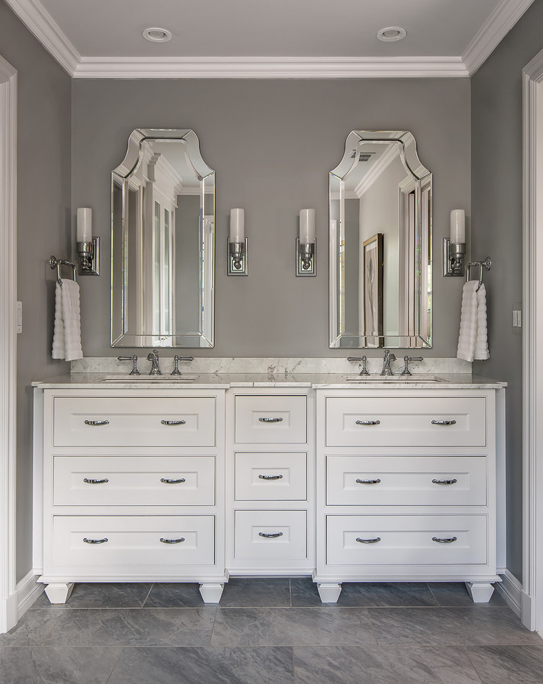 Inspiration for a medium sized traditional ensuite bathroom in Detroit with freestanding cabinets, white cabinets, a freestanding bath, a double shower, a two-piece toilet, white tiles, grey walls, a submerged sink, marble worktops, grey floors, a hinged door, metro tiles, ceramic flooring and white worktops.