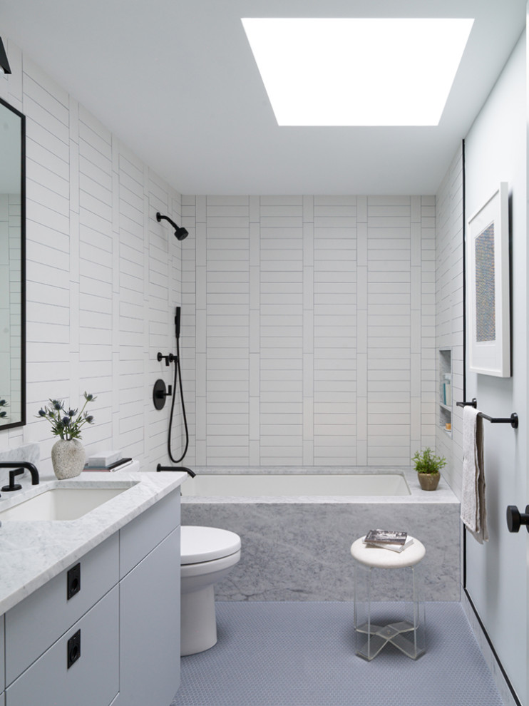 Inspiration för ett 50 tals vit vitt badrum, med släta luckor, grå skåp, ett undermonterat badkar, en dusch/badkar-kombination, vit kakel, vita väggar, ett undermonterad handfat, grått golv och med dusch som är öppen