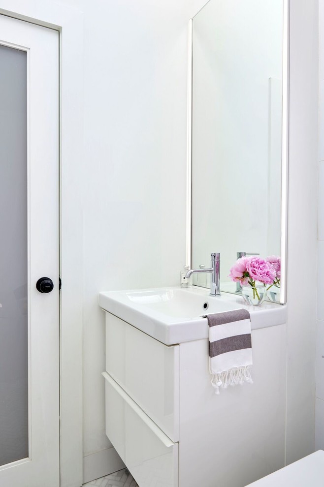 Foto di una piccola stanza da bagno moderna con ante lisce, ante bianche, pareti bianche, pavimento con piastrelle in ceramica, lavabo integrato e top in superficie solida