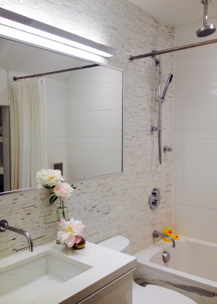Cette photo montre une salle de bain chic pour enfant avec un placard à porte plane, des portes de placard blanches, WC à poser, un carrelage gris, mosaïque, un mur blanc, un sol en marbre, un lavabo encastré, un plan de toilette en quartz modifié et un sol blanc.