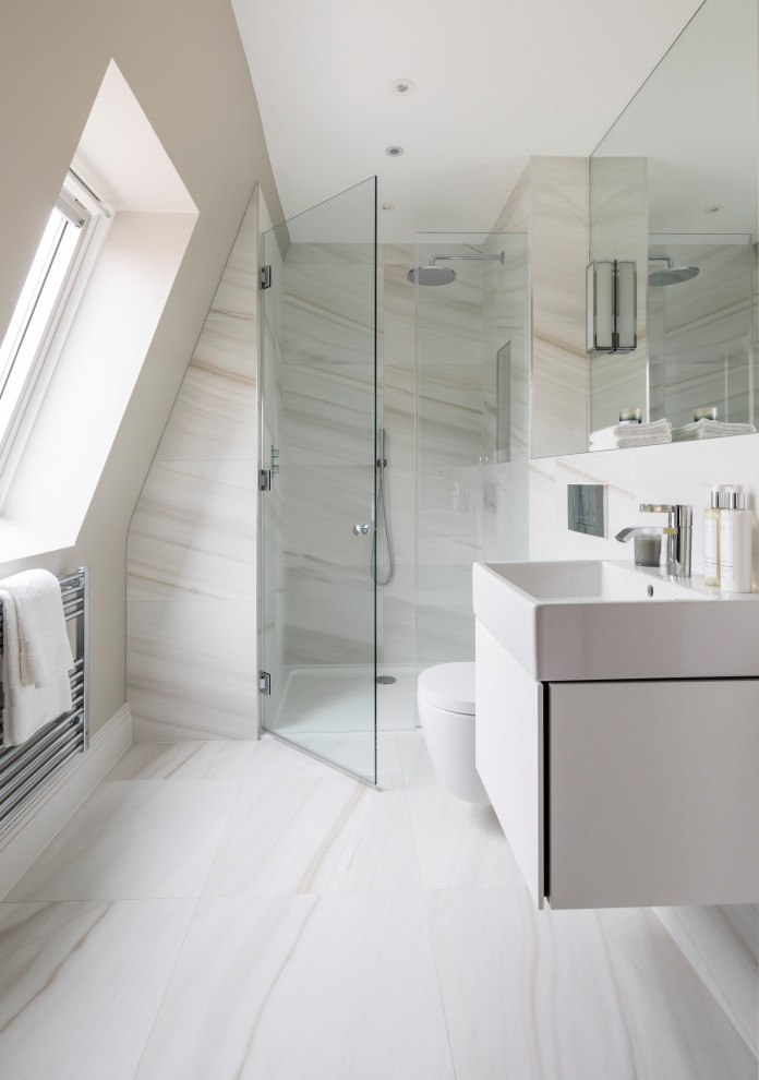 This is an example of a medium sized contemporary shower room bathroom in London with flat-panel cabinets, white cabinets, an alcove shower, a wall mounted toilet, beige tiles, porcelain tiles, beige walls, porcelain flooring, an integrated sink, beige floors, a shower curtain and white worktops.