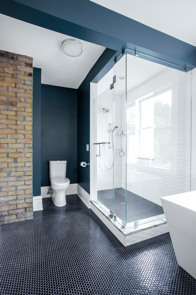 Пример оригинального дизайна: огромная главная ванная комната в классическом стиле с фасадами островного типа, черными фасадами, отдельно стоящей ванной, угловым душем, унитазом-моноблоком, белой плиткой, керамической плиткой, синими стенами, полом из мозаичной плитки, врезной раковиной, столешницей из гранита, черным полом, душем с распашными дверями и белой столешницей