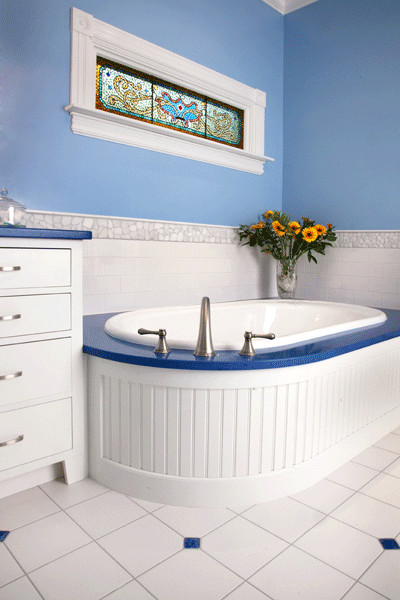 Esempio di una stanza da bagno padronale chic di medie dimensioni con consolle stile comò, ante bianche, vasca da incasso, piastrelle bianche, piastrelle di vetro, pareti blu, pavimento in gres porcellanato e top in quarzo composito