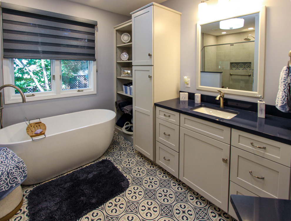 Пример оригинального дизайна: главная ванная комната среднего размера в стиле неоклассика (современная классика) с плоскими фасадами, серыми фасадами, отдельно стоящей ванной, угловым душем, раздельным унитазом, серой плиткой, плиткой кабанчик, серыми стенами, полом из известняка, врезной раковиной, столешницей из искусственного кварца, синим полом, душем с распашными дверями и синей столешницей