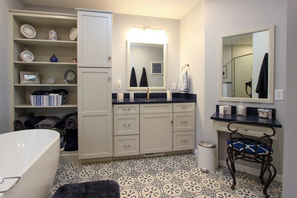 Example of a mid-sized transitional master gray tile and subway tile limestone floor and blue floor bathroom design in Cleveland with flat-panel cabinets, gray cabinets, a two-piece toilet, gray walls, an undermount sink, quartz countertops, a hinged shower door and blue countertops