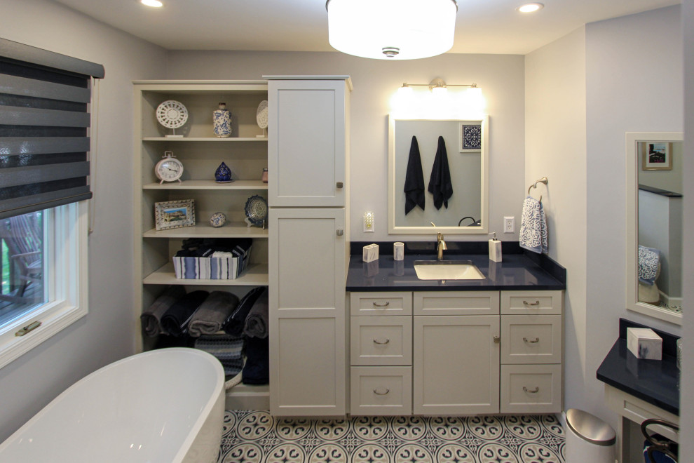 Пример оригинального дизайна: главная ванная комната среднего размера в стиле неоклассика (современная классика) с плоскими фасадами, серыми фасадами, отдельно стоящей ванной, угловым душем, раздельным унитазом, серой плиткой, плиткой кабанчик, серыми стенами, полом из известняка, врезной раковиной, столешницей из искусственного кварца, синим полом, душем с распашными дверями и синей столешницей
