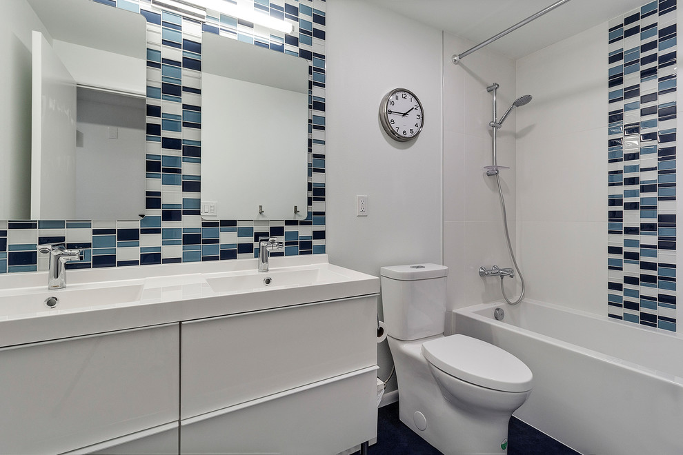 Small minimalist kids' blue tile and mosaic tile linoleum floor and blue floor bathroom photo in Portland with flat-panel cabinets, white cabinets, white walls, an integrated sink, white countertops, a two-piece toilet and quartz countertops