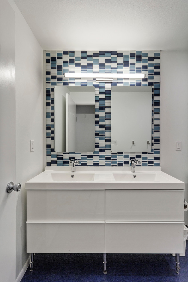 Bild på ett litet funkis vit vitt badrum för barn, med släta luckor, vita skåp, en dusch/badkar-kombination, mosaik, ett integrerad handfat, dusch med duschdraperi, blå kakel, vita väggar, linoleumgolv, blått golv och bänkskiva i kvarts
