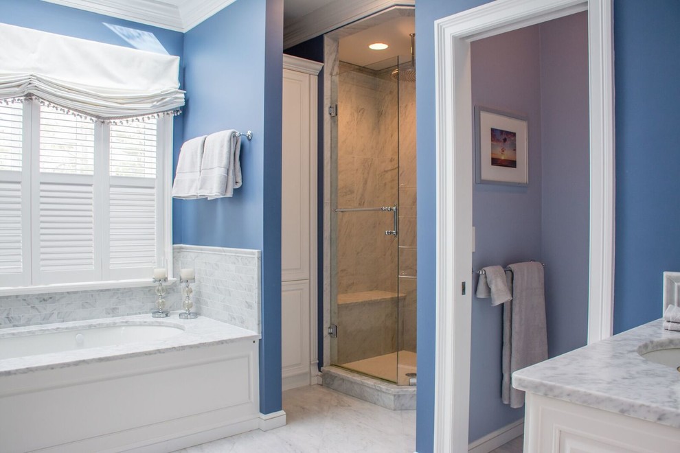 Cette image montre une grande salle de bain principale traditionnelle avec un placard en trompe-l'oeil, des portes de placard blanches, une baignoire encastrée, une douche d'angle, un carrelage gris, un mur bleu, un sol en marbre, un plan de toilette en marbre, un sol gris et une cabine de douche à porte battante.