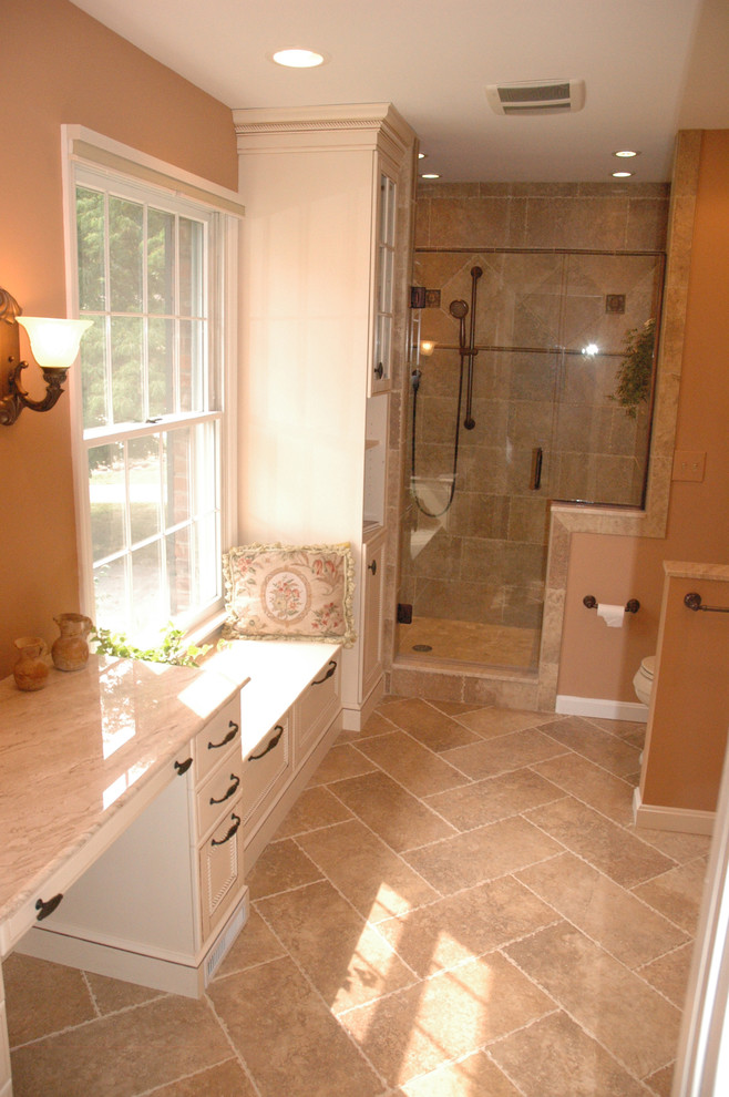 Exempel på ett stort klassiskt en-suite badrum, med ett undermonterad handfat, luckor med infälld panel, vita skåp, brun kakel, keramikplattor, bruna väggar och travertin golv
