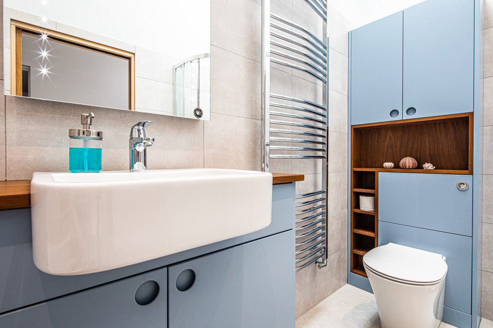 Idee per una stanza da bagno per bambini minimalista di medie dimensioni con ante blu, piastrelle grigie, pareti grigie, top in legno, pavimento grigio, porta doccia scorrevole, top marrone e un lavabo