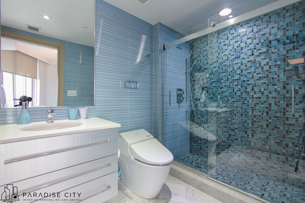 На фото: детская ванная комната среднего размера в современном стиле с плоскими фасадами, серыми фасадами, душем в нише, унитазом-моноблоком, черной плиткой, синей плиткой, разноцветной плиткой, плиткой мозаикой, синими стенами, мраморным полом, врезной раковиной и столешницей из искусственного камня с