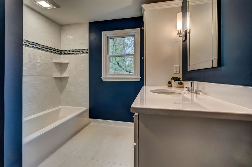 На фото: детская ванная комната среднего размера в стиле неоклассика (современная классика) с фасадами в стиле шейкер, белыми фасадами, ванной в нише, раздельным унитазом, белой плиткой, керамогранитной плиткой, синими стенами, полом из керамогранита, врезной раковиной, столешницей из искусственного кварца и белым полом