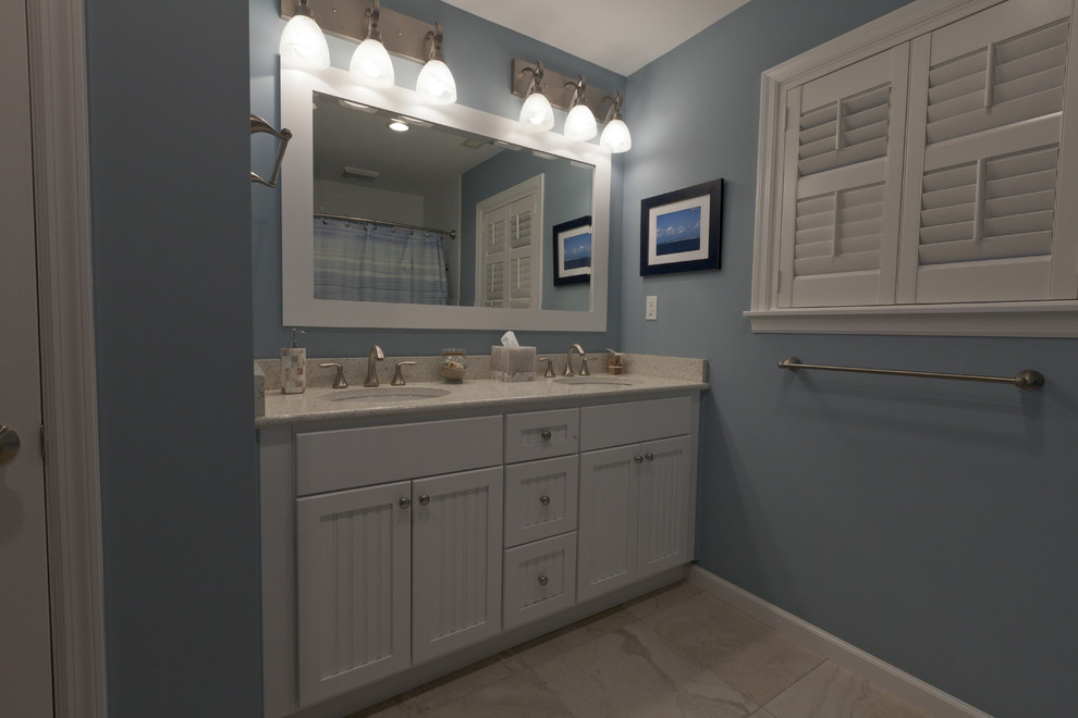 Inspiration för ett mellanstort maritimt badrum, med ett undermonterad handfat, luckor med infälld panel, vita skåp, bänkskiva i kvarts, ett badkar i en alkov, en dusch/badkar-kombination, en toalettstol med separat cisternkåpa, beige kakel, porslinskakel, blå väggar och klinkergolv i porslin