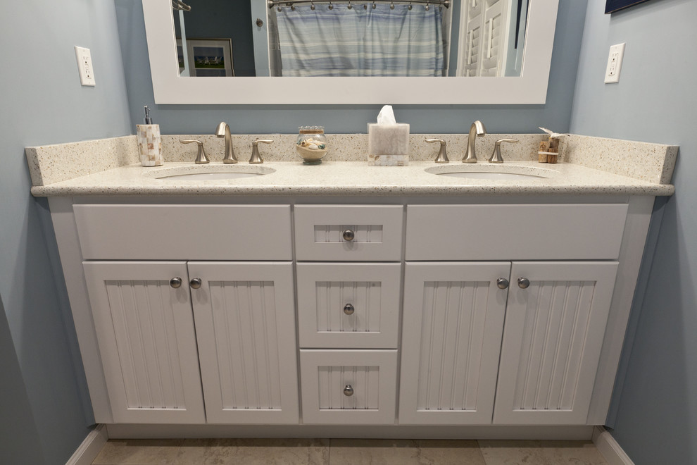 Inspiration for a mid-sized coastal beige tile and porcelain tile porcelain tile bathroom remodel in Bridgeport with an undermount sink, recessed-panel cabinets, white cabinets, quartz countertops, a two-piece toilet and blue walls