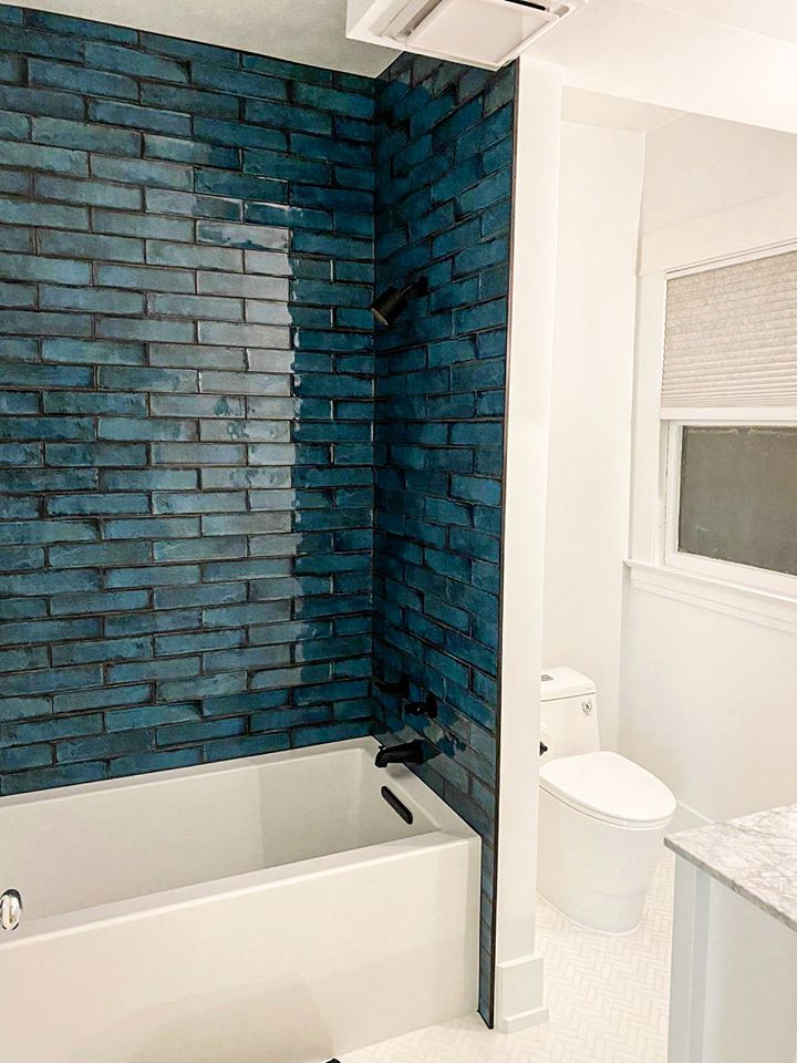 Foto di una stanza da bagno padronale moderna di medie dimensioni con ante bianche, vasca ad alcova, vasca/doccia, piastrelle blu, piastrelle in ceramica, pareti bianche, lavabo sottopiano, doccia aperta e un lavabo