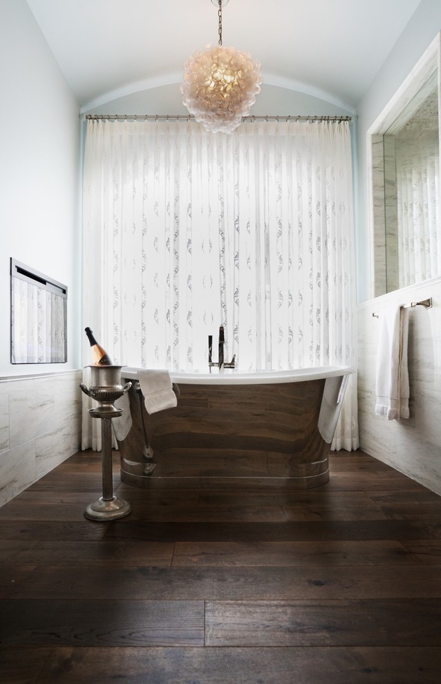 Klassisk inredning av ett mycket stort vit vitt en-suite badrum, med luckor med upphöjd panel, vita skåp, ett fristående badkar, en dubbeldusch, en bidé, vit kakel, marmorkakel, blå väggar, mellanmörkt trägolv, ett fristående handfat, marmorbänkskiva, brunt golv och dusch med gångjärnsdörr
