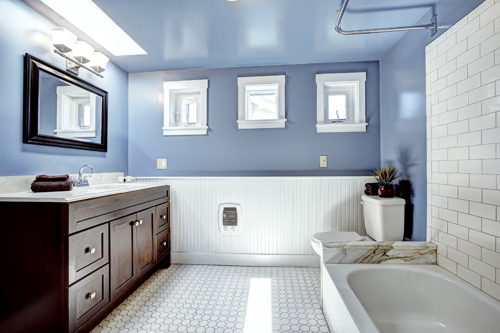 На фото: главная ванная комната в стиле кантри с фасадами островного типа, плиткой кабанчик, синими стенами, полом из керамической плитки, темными деревянными фасадами, накладной ванной, раздельным унитазом, белой плиткой и накладной раковиной