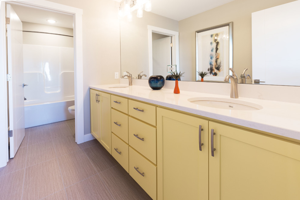 Bathroom - mid-sized transitional master beige tile and ceramic tile ceramic tile bathroom idea in Minneapolis with shaker cabinets, yellow cabinets, a two-piece toilet, beige walls, an undermount sink and marble countertops