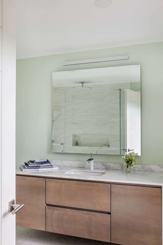 Inspiration for a mid-sized contemporary 3/4 white tile ceramic tile and white floor corner shower remodel in Boston with flat-panel cabinets, medium tone wood cabinets, a one-piece toilet, blue walls, a console sink, marble countertops and a hinged shower door