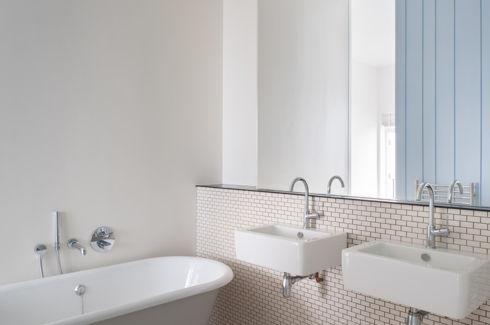 Photo of a medium sized traditional ensuite bathroom in London with a wall-mounted sink, a claw-foot bath, a wall mounted toilet, beige tiles, porcelain tiles, white walls and porcelain flooring.