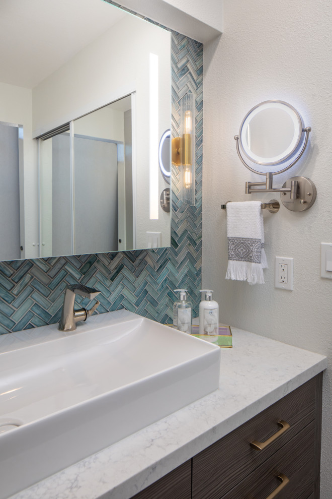Großes Badezimmer En Suite mit flächenbündigen Schrankfronten, dunklen Holzschränken, Nasszelle, Toilette mit Aufsatzspülkasten, blauen Fliesen, weißer Wandfarbe, Aufsatzwaschbecken, Quarzwerkstein-Waschtisch, grünem Boden, Falttür-Duschabtrennung und weißer Waschtischplatte in San Diego