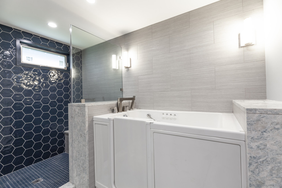 Пример оригинального дизайна: большая главная ванная комната в стиле неоклассика (современная классика) с фасадами с утопленной филенкой, белыми фасадами, ванной в нише, душем в нише, унитазом-моноблоком, синей плиткой, стеклянной плиткой, синими стенами, полом из керамогранита, врезной раковиной, столешницей из искусственного кварца, бежевым полом, душем с распашными дверями, серой столешницей, сиденьем для душа, тумбой под две раковины и встроенной тумбой