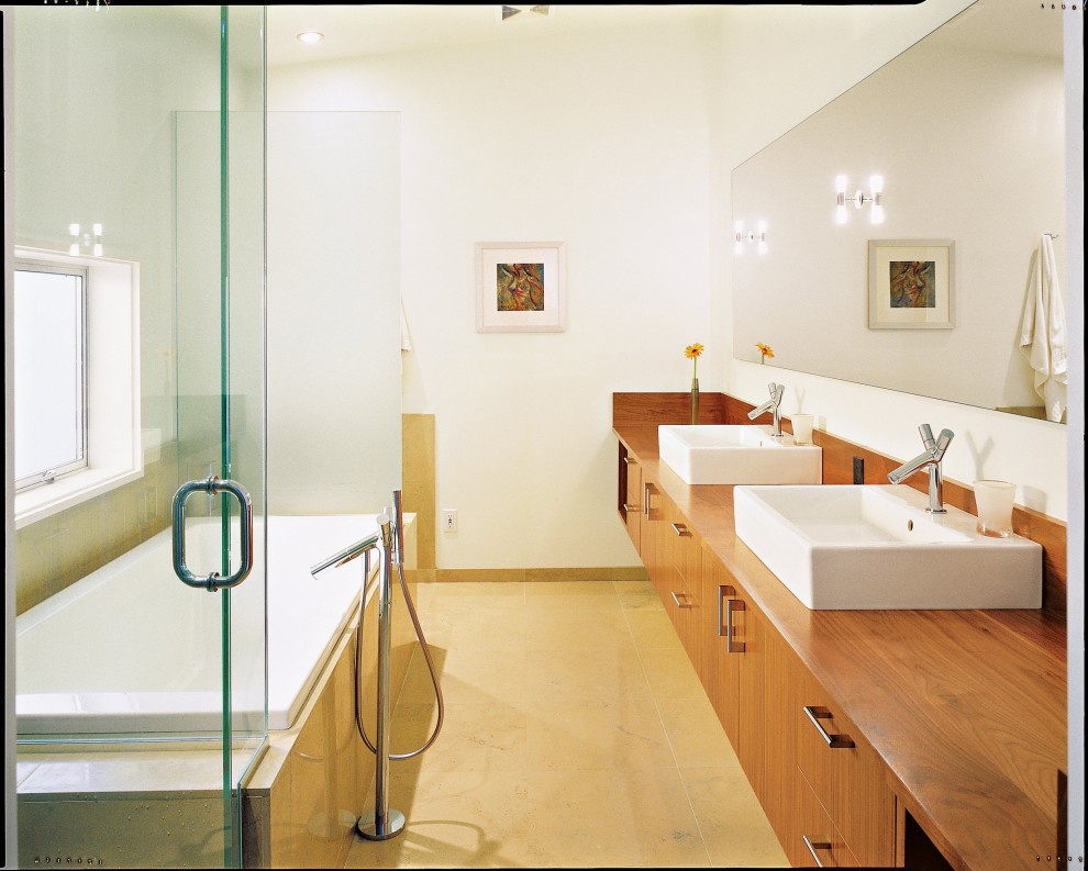 Cette photo montre une salle de bain moderne avec une vasque et un plan de toilette en bois.