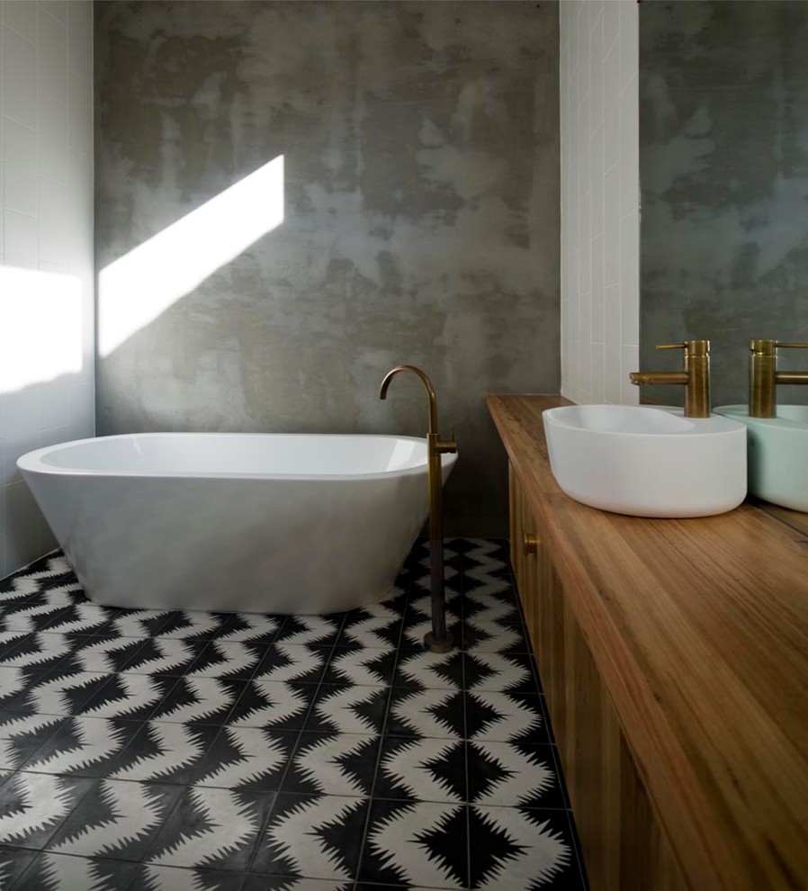 Freestanding bathtub - mid-sized contemporary master cement tile ceramic tile freestanding bathtub idea in Melbourne with a vessel sink, flat-panel cabinets, medium tone wood cabinets, wood countertops, gray walls and brown countertops